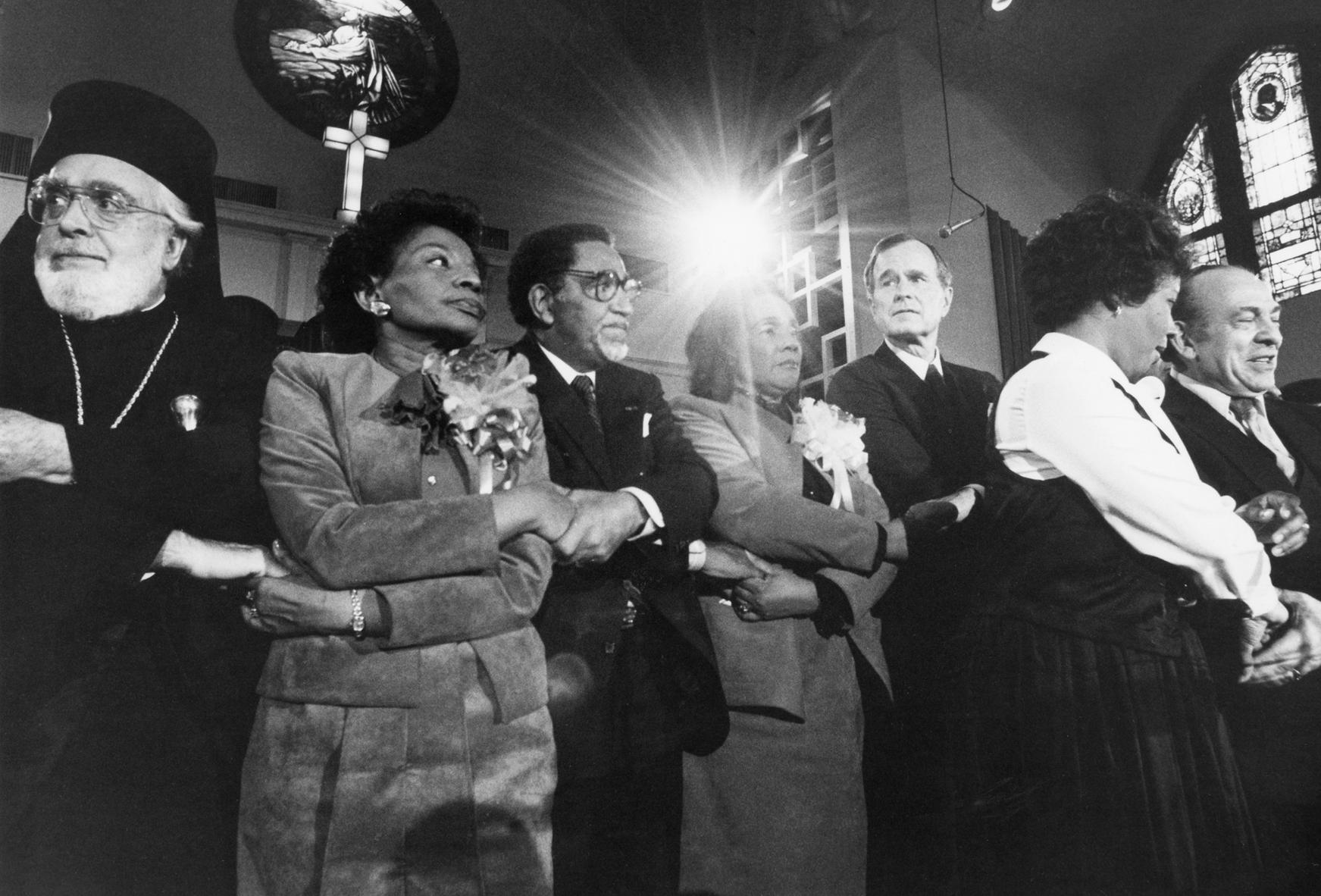Archbishop Iakovos with arms locked together with Coretta Scott King (MLK's widow) and Pres. G.W. Bush at an MLK Day celebration